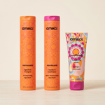 Amika hair care products including shampoo, conditioner, and mask on a beige background