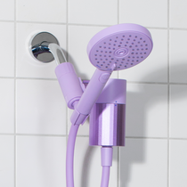 Lilac handheld shower head and hose attached to a shower arm on a tiled bathroom wall.