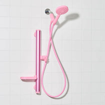 Pink shower kit and handheld shower on a white tiled background
